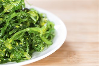 Fresh made Kelp Salad (close-up shot) on wooden background