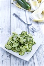 Homemade Cucumber Salad with onions and dill on a wooden table