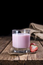 Homemade Strawberry Milk (selective focus) on an old wooden table