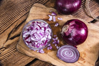 Small bowl with (diced) Red Onions on wooden background