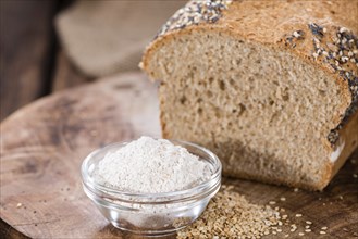 Fresh baked bread with seeds on rustic wooden background