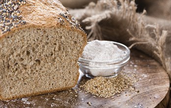 Homemade loaf of bread on dark wooden background