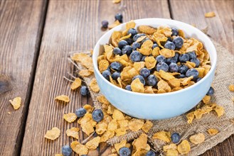 Portion of Cornflakes with fresh Blueberries (close-up shot)