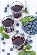 Blueberry Liqueur with some fresh fruits in a small glass