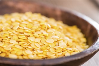 Portion of Yellow Lentils on vintage wooden background