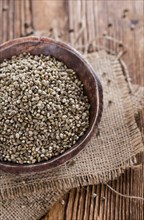 Portion of Hemp Seeds (close-up shot) on an old wooden table