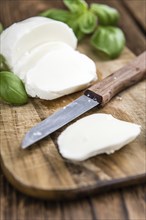 Old wooden table with Mozzarella as detailed close-up shot (selective focus)