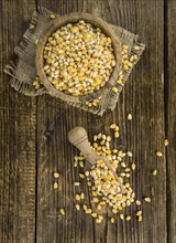 Dried Corn (detailed close-up shot, selective focus) on vintage wooden background