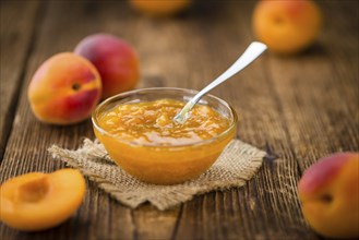 Apricot Jam on an old wooden table as detailed close-up shot (selective focus)