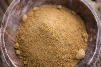 Portion of golden Coconut Sugar (selective focus) on vintage wooden background