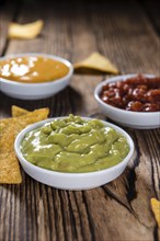 Different sorts of Nacho Dips (soft focus) on wooden background