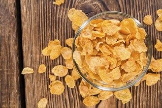 Portion of golden Cornflakes on wooden background (close-up shot)