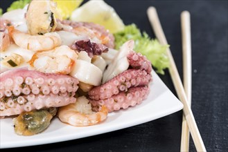 Fresh made Seafood Salad with shrimps, mussels and quid (close-up shot)