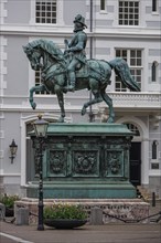 Bronze statue of a horseman on a pedestal in front of a historic building, The Hague, Netherlands