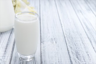 Portion of Milk on wooden background (close-up shot)