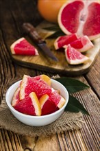 Sliced Grapefruit (close-up shot) on rustic wooden background