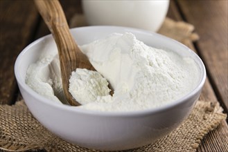 Portion of Milk Powder (selective focus) on an old wooden table