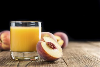 Fresh made Peach juice (detailed close-up shot) on wooden background