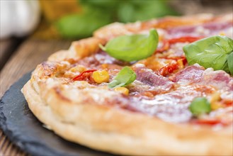 Salami Pizza (close-up shot) topped with fresh basil