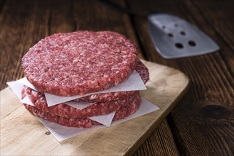 A raw Burger (minced Beef) on dark wooden background