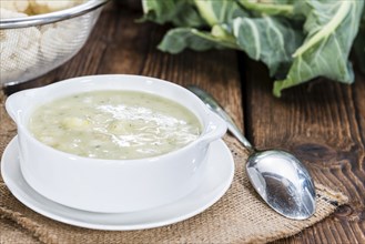 Cauliflower Soup in a small bowl (close-up shot) on wooden background