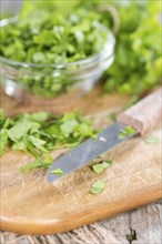 Heap of fresh cutted flat leaf Parsley (on wooden background)