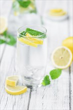 Homemade Lemonade on an wooden table (selective focus) as detailed close-up shot