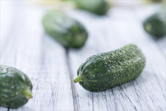 Small green Gherkins (detailed close-up shot) on wooden background