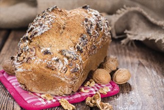 Fresh baked Walnut Bread (close-up shot) on wooden background