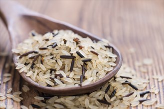 Mixed Rice on a wooden Spoon (on rustic background)