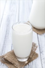 Portion of Milk on bright wooden background (close-up shot)