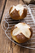 Salty Pretzel Roll (close-up shot) on rustic wooden background