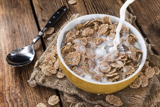 Pouring Milk on a portion of Cornflakes (in a bowl)