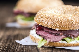 Roast Beef Bagel (selective focus) on vintage background (close-up shot)