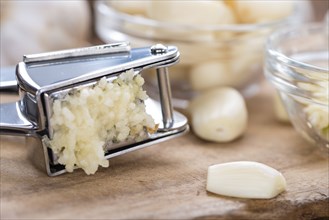 Portion of Crushed Garlic (close-up shot) on wooden background