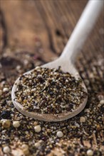 Wooden spoon with crushed Peppercorns (detailed close-up shot)