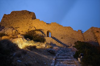 Night shot, Old castle ruins with illuminated stone steps and an archway at night, Kritinia Castle,