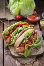 Homemade Hot Dog with fresh vegetables on rustic wooden background