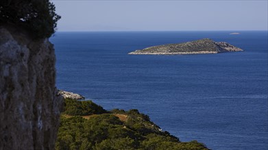 A coastal landscape with a view of an island in the blue sea and dense vegetation, Kritinia Castle,