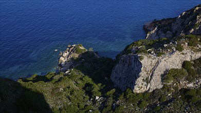 A rocky coast with deep blue sea and dense vegetation on cliffs, Kritinia Castle, St John's Castle,