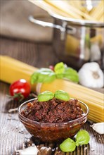 Fresh made Tomato Pesto (close-up shot) on wooden background