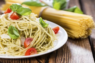 Portion of Italian food (Spaghetti with Pesto, Parmesan Cheese and Tomatoes)