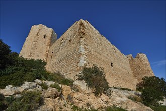 Close-up of an old castle ruin with massive stone walls and deep blue sky in the background,