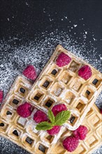 Fresh made Waffles with Raspberries and powder sugar (close-up shot)