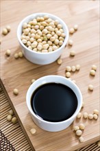 Soy Sauce in a bowl (close-up shot) on bamboo background