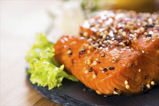 Piece of Smoked Salmon on wooden background (close-up shot)