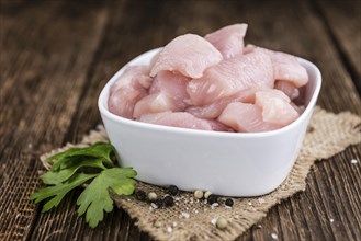 Portion of chopped Chicken Fillet (close-up shot) on wooden background