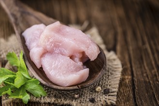 Portion of chopped Chicken Fillet (close-up shot) on wooden background