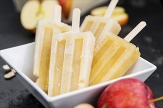 Portion of homemade Apple Popsicles (selective focus, close-up shot) on a vintage background