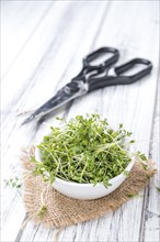 Fresh Garden Cress as close-up shot with selective focus on wooden background